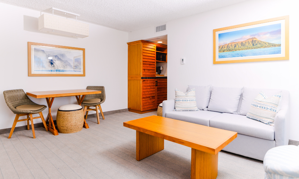 Living room with couch and dining table in Signature Mahalo King Suite at our Diamond Beach resort