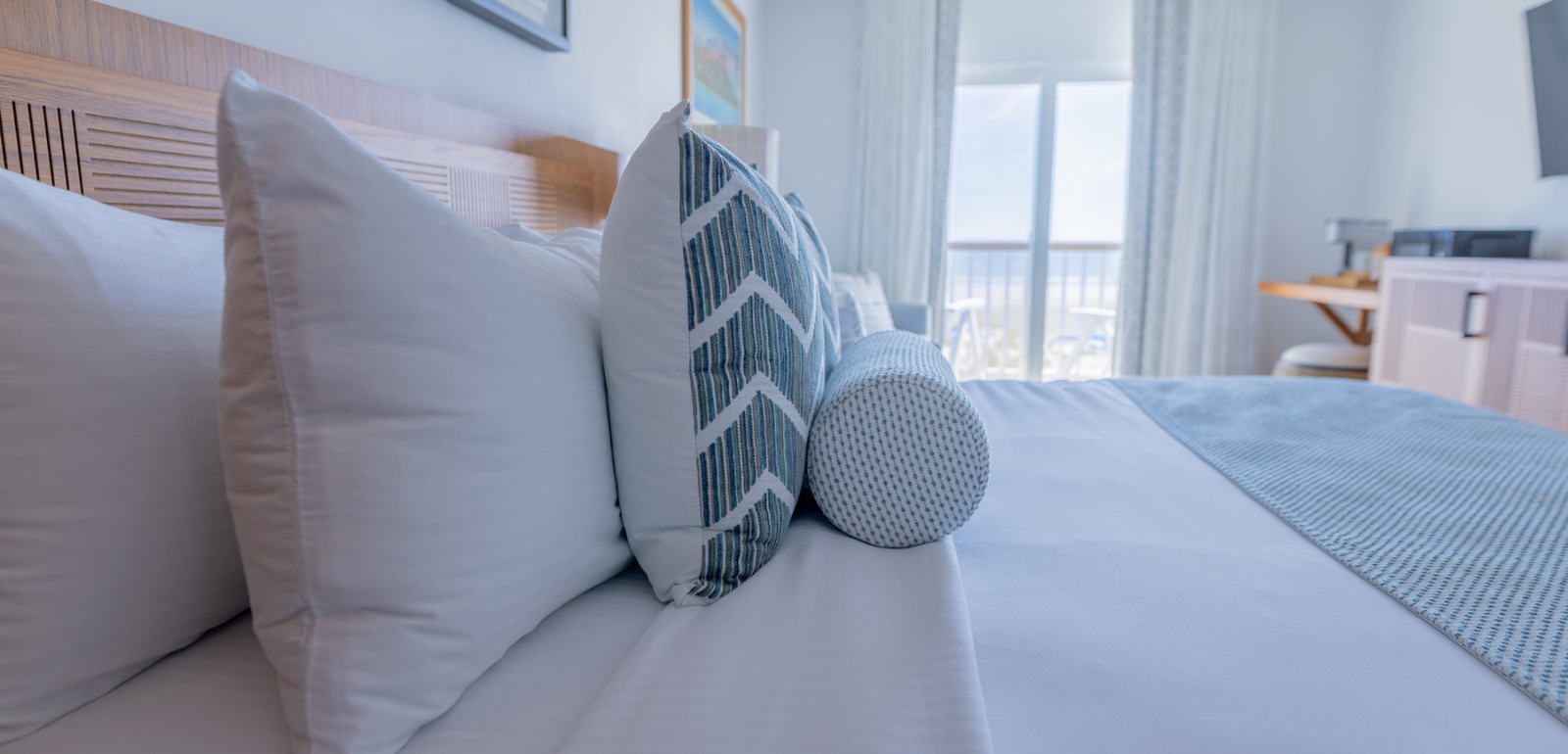 Neatly made bed with pillows stacked in the Oceanfront King Studio at our Diamond Beach NJ hotel