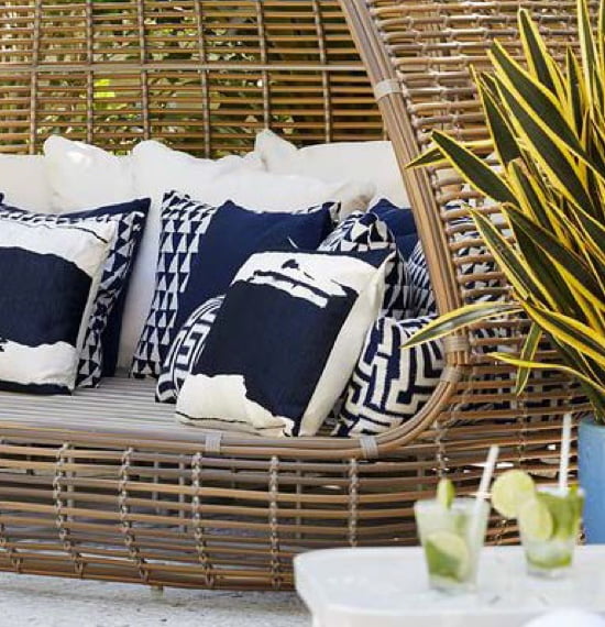 Wicker couch with blue and white pillows