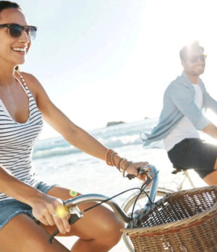 Couple riding bicycles on the beach