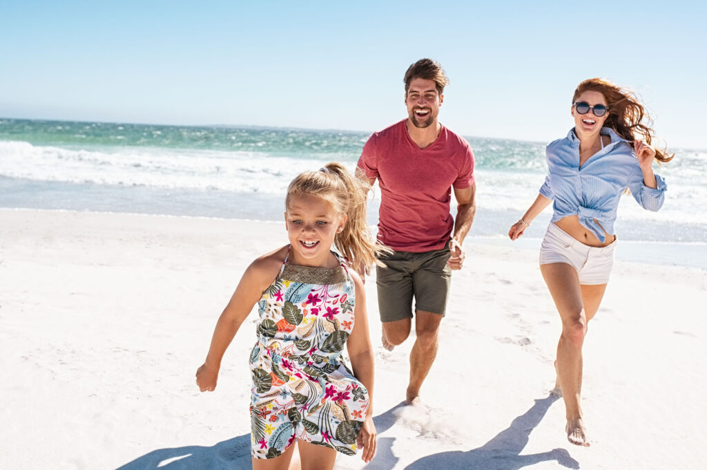 Young happy family running on beach