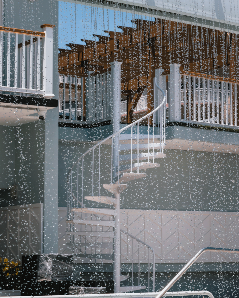 A staircase seen through the pool waterfall at our Diamond Beach resort