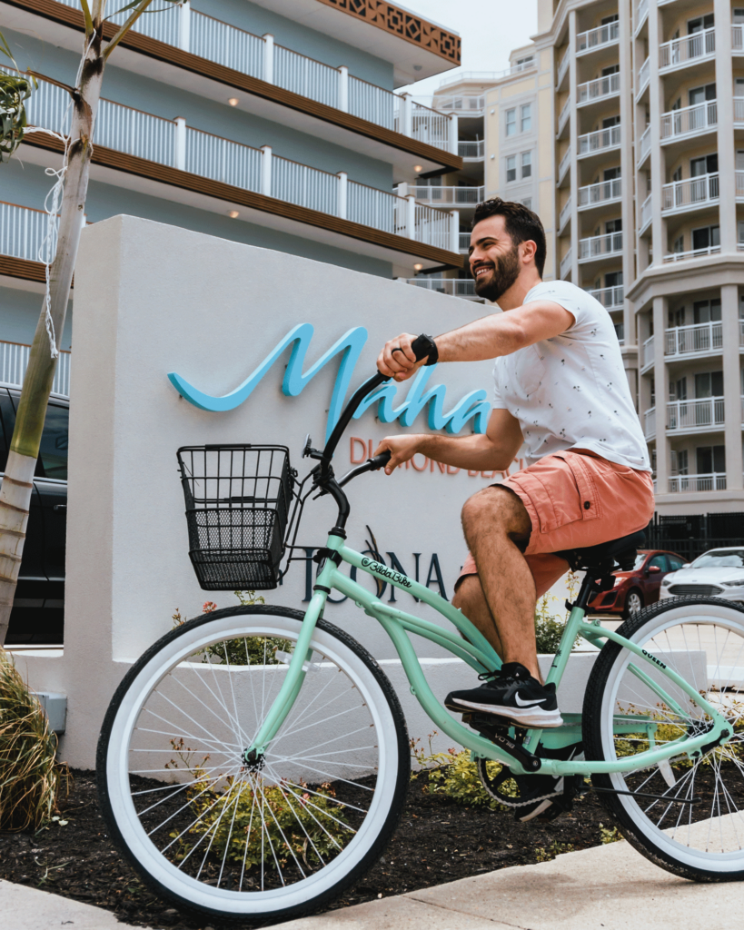 A man rides a cruiser bike near the entrance to our Mahalo Diamond Beach hotel