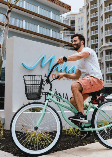 A man rides a cruiser bike near the entrance to our Mahalo Diamond Beach hotel