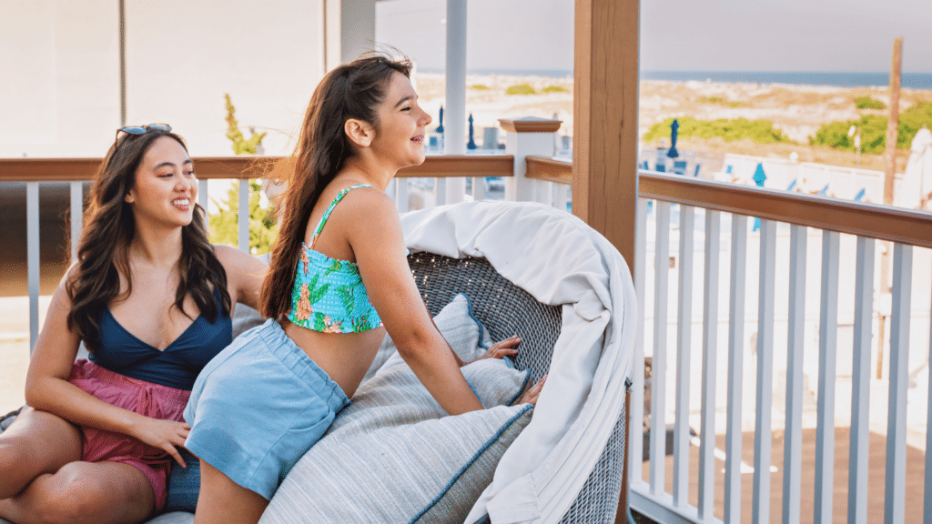 Mother and daughter looking out at a beach view from a rooftop deck at Mahalo Diamond Beach resort