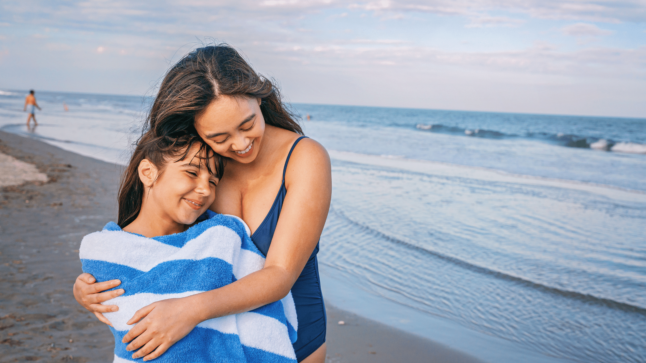 Mother and daughter hugging on a family-friendly beach