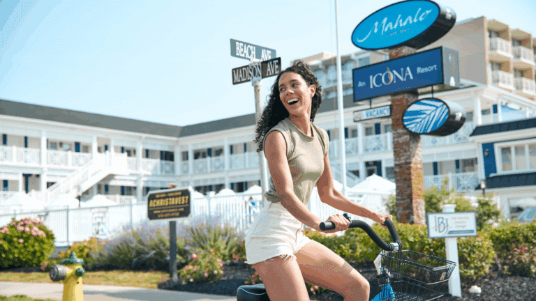 Woman riding a bicycle in front of Mahalo Cape May