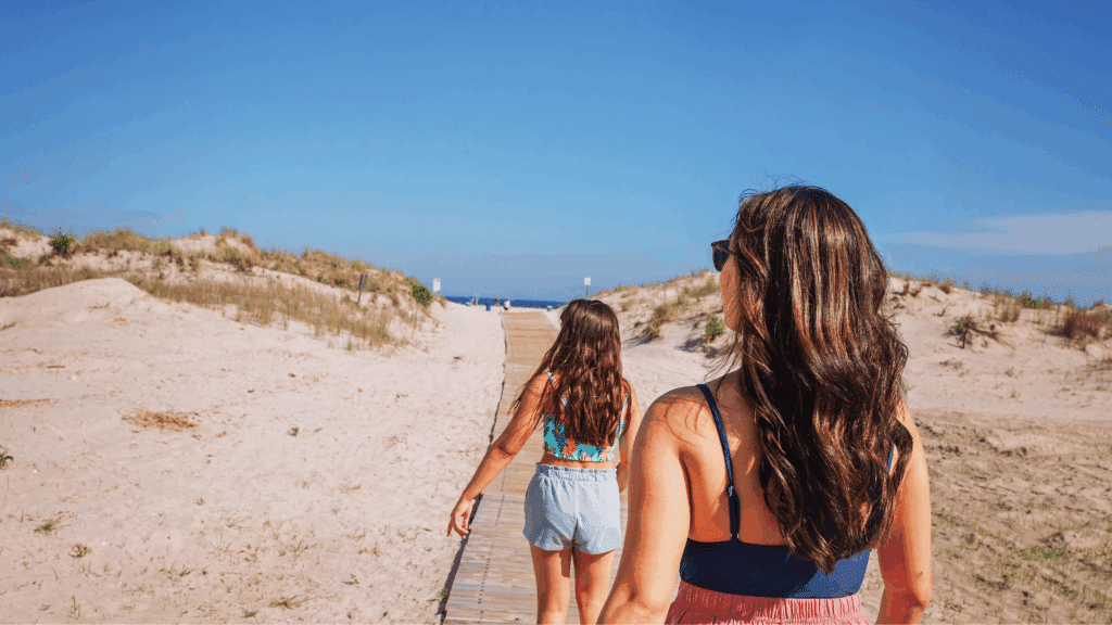 A woman and a young girl walking onto the beach in Wildwood, NJ